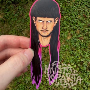 May include: A die-cut sticker featuring a stylised illustration of a person with a dark brown mullet hairstyle, a thin moustache, and glowing white eyes. The sticker has a vibrant neon pink border and includes the text MUSTA SPARTA in white.