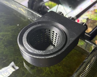 May include: A black, 3D-printed aquarium filter with a cylindrical mesh basket. The filter has a rectangular mounting bracket with three adjustment knobs. The filter is designed to sit inside an aquarium.