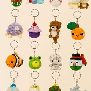 May include: A collection of colorful, crocheted keychains in various shapes, including animals, food, and vehicles. The keychains feature a reindeer, airplane, unicorn, cats, turtle, cupcake, bear, orange, clownfish, frog, snowman, police car, taxi, and shark.