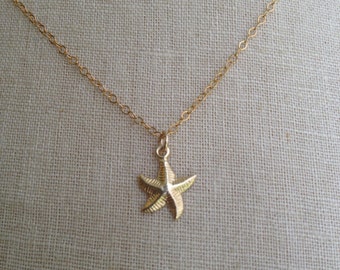 May include: A gold chain necklace with a small gold starfish pendant.