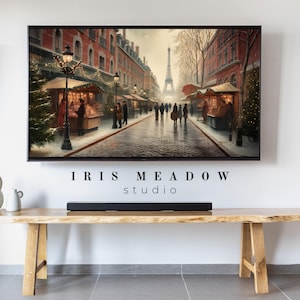 May include: A framed print of a Parisian street scene with the Eiffel Tower in the distance. The artwork depicts a winter market with stalls, streetlights, and figures. The text "IRIS MEADOW studio" is at the bottom.