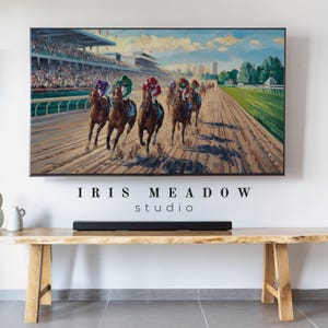 May include: A painting of a horse race with jockeys in colorful silks riding thoroughbred horses on a dirt track. The painting is framed and hanging on a wall above a wooden table with a soundbar.