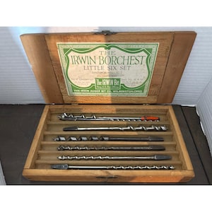 May include: A wooden box set containing six auger bits. The box lid features a green and white label with the text "THE IRWIN BORCHEST LITTLE SIX SET". The bits are arranged in individual slots within the box.