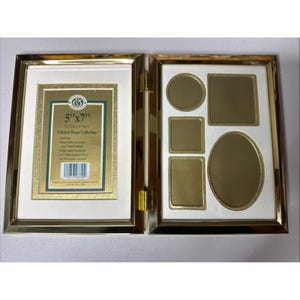 May include: A hinged, gold-toned metal picture frame with multiple openings. One side holds a 5"x7" (12.7cm x 17.8cm) photo, the other has various shaped openings. The frame has a white matting and is from the "Polished Brass Collection".