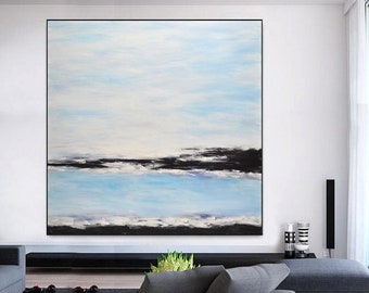 May include: Abstract painting with a blue and white sky and a black horizon line. The painting is hanging on a white wall in a modern living room.
