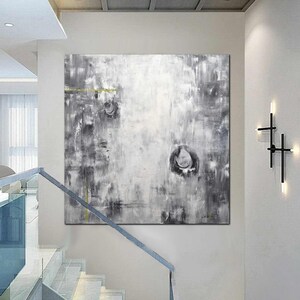 May include: Abstract painting in shades of gray and white with hints of gold. The painting features a textured, layered style with circular shapes and lines.