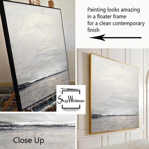 Puede incluir: Pintura abstracta de paisaje en tonos grises y blancos con un toque de plata. La pintura est&aacute; enmarcada en un marco flotante negro y se apoya en un caballete de madera. La pintura se titula "Sky Whitman" y se describe como "Arte Moderno Original".