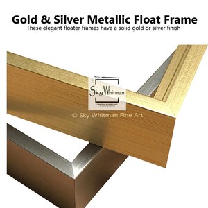 May include: Close-up of a corner of a gold and silver metallic floater frame. The frame has a solid gold or silver finish. "Sky Whitman Original Modern Art" is printed on the frame.