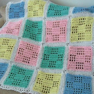 May include: A crocheted baby blanket with a white border and squares in pastel colors of blue, green, pink, and yellow.