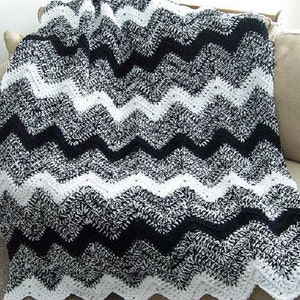 May include: Black and white chevron crochet throw blanket with a textured, fuzzy look.