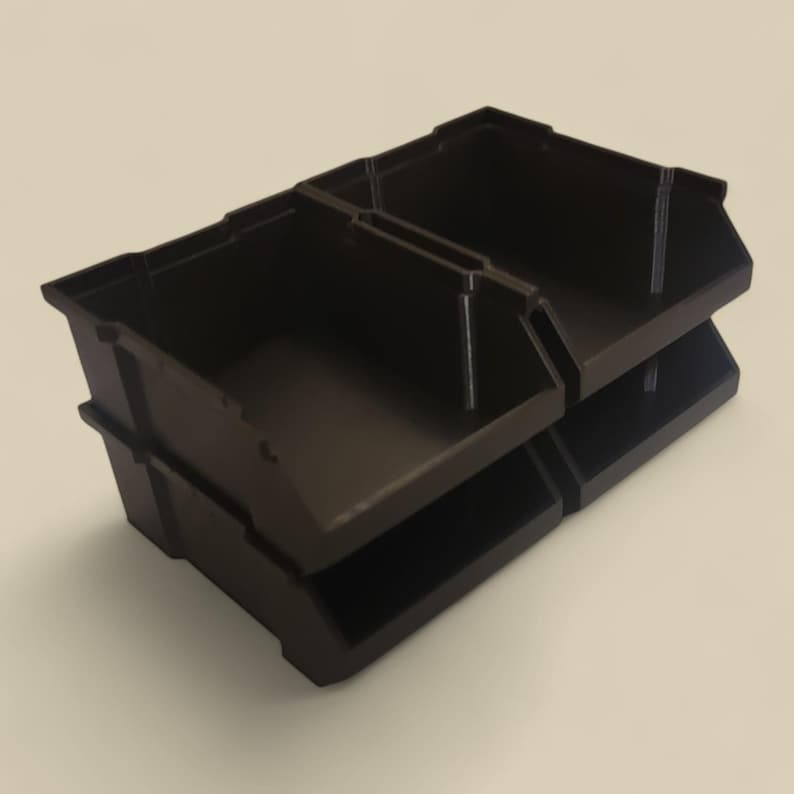 K&ouml;nnte beinhalten: Eine dunkelbraune, zweistufige Aufbewahrungsbox. Die Box besteht aus einem robusten Kunststoffmaterial und verf&uuml;gt &uuml;ber ein gestapeltes Design mit offenen F&auml;chern. Ideal zum Organisieren kleiner Gegenst&auml;nde in einer Werkstatt oder einem Bastelraum.