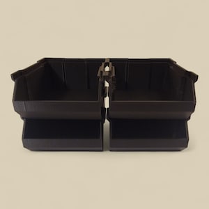 K&ouml;nnte beinhalten: Zwei dunkelbraune Kunststoff-Aufbewahrungsboxen, die durch ein zentrales Scharnier verbunden sind. Jede Box hat eine rechteckige Form mit einem unteren Regal und einer leicht abgewinkelten Oberkante. Die Boxen sind f&uuml;r die Organisation kleiner Gegenst&auml;nde konzipiert.