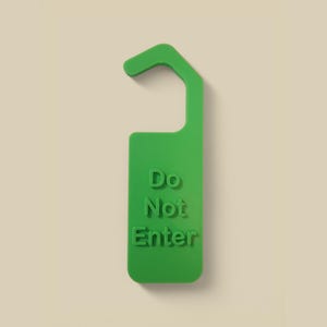 May include: Green plastic do not disturb sign with a hook for a door knob. The sign reads "Do Not Enter".