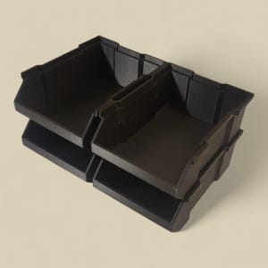 K&ouml;nnte beinhalten: Schwarze Kunststoff-Aufbewahrungsboxen, zweist&ouml;ckig gestapelt. Die Boxen haben eine strukturierte Oberfl&auml;che und sind mit einem geteilten Innenraum zur Organisation ausgestattet. Das Design ist einfach und funktional, geeignet f&uuml;r verschiedene Aufbewahrungsbed&uuml;rfnisse.