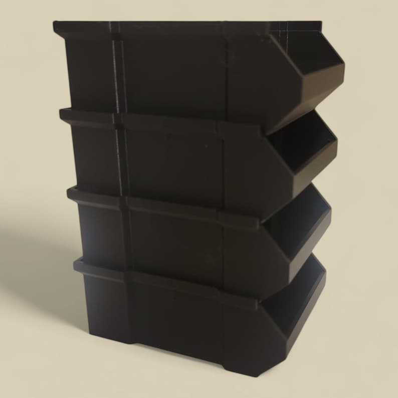 K&ouml;nnte beinhalten: Ein stapelbarer schwarzer Aufbewahrungsbeh&auml;lter mit vier abgewinkelten F&auml;chern. Die Beh&auml;lter bestehen aus einem soliden Material und sind f&uuml;r die Aufnahme kleiner Gegenst&auml;nde konzipiert. Das Design ist einfach und funktional.