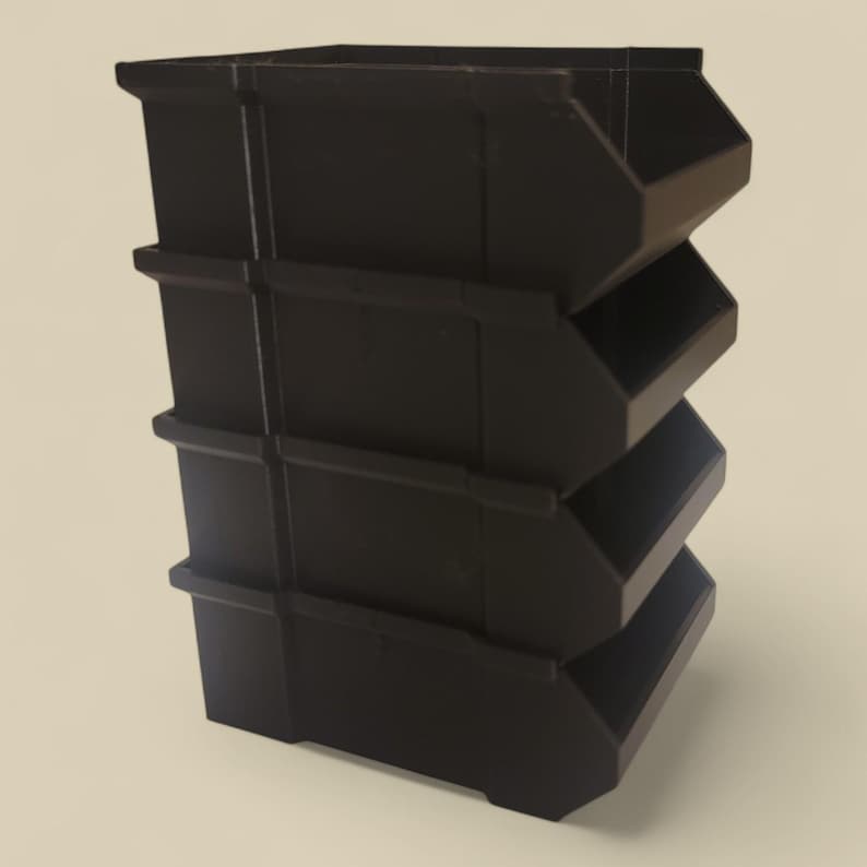 K&ouml;nnte beinhalten: Ein Stapel von vier schwarzen Kunststoff-Aufbewahrungsboxen. Jede Box hat eine offene Vorderseite und ein leicht abgewinkeltes Design, wodurch ein gestuftes Aussehen entsteht. Die Boxen sind zum Organisieren und Aufbewahren von Gegenst&auml;nden konzipiert.