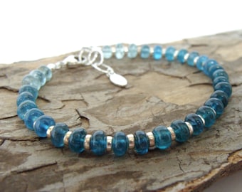May include: A blue and teal ombre gemstone bracelet with silver beads and a silver clasp.