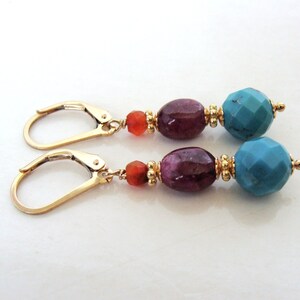 May include: Gold dangle earrings with turquoise, purple and orange beads.