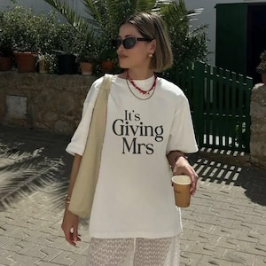 Koszulka „Its Giving Mrs” – Koszulka „Bliska Panna Młoda” | Bluzka zaręczynowa | Strój na wieczór panieński, miękka bawełna