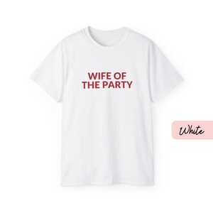 May include: A white ceramic mug with a black handle and the text "But First, Coffee" in a black, handwritten-style font. The mug is on a white surface.