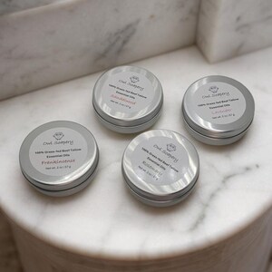 May include: Four small silver tins with white labels. Each tin contains 100% grass-fed beef tallow and essential oils. The labels list the scents: Frankincense, Sandalwood, Lavender, and Rosemary.