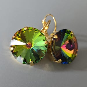 May include: A pair of gold earrings with iridescent green and rainbow crystal stones.