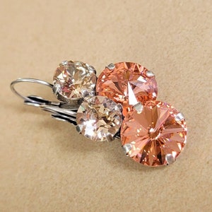 May include: Silver dangle earrings with three peach and light pink crystal stones.