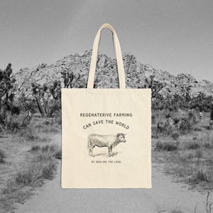 May include: A beige tote bag with the text "Regenerative Farming Can Save The World By Healing The Land." and a black and white illustration of a cow.