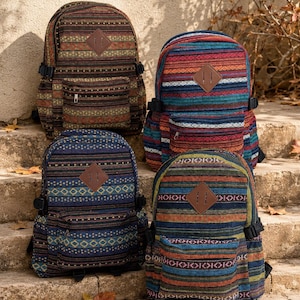 May include: Four backpacks with woven fabric featuring horizontal stripes and geometric patterns in various colors including blue, red, green, and brown. Each bag has a brown diamond-shaped faux leather patch on the front and a zippered pocket.