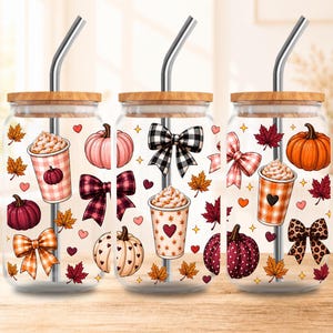 May include: Three clear glass tumblers with bamboo lids and metal straws, each featuring a festive autumn pattern of pumpkins, coffee cups with whipped cream, plaid bows, and colorful fall leaves in shades of orange, pink, and deep red.
