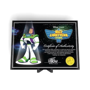 Könnte beinhalten: Eine rechteckige Disney Pixar Buzz Lightyear of Star Command Echtheitszertifikat-Plakette. Der schwarze Hintergrund zeigt ein Weltraumthema mit einer Grafik von Buzz Lightyear, dem Filmlogo und einem Text, signiert von Tad Stones, Regisseur.