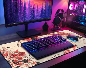 May include: A gaming setup featuring a black keyboard with blue and purple backlighting, a mouse, and a floral-patterned mousepad. A computer monitor displays a purple and pink landscape. A headset and a desktop computer are also visible.
