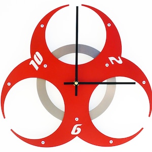 May include: A red biohazard symbol clock with black hands and white numbers. The clock has a silver ring around the center.