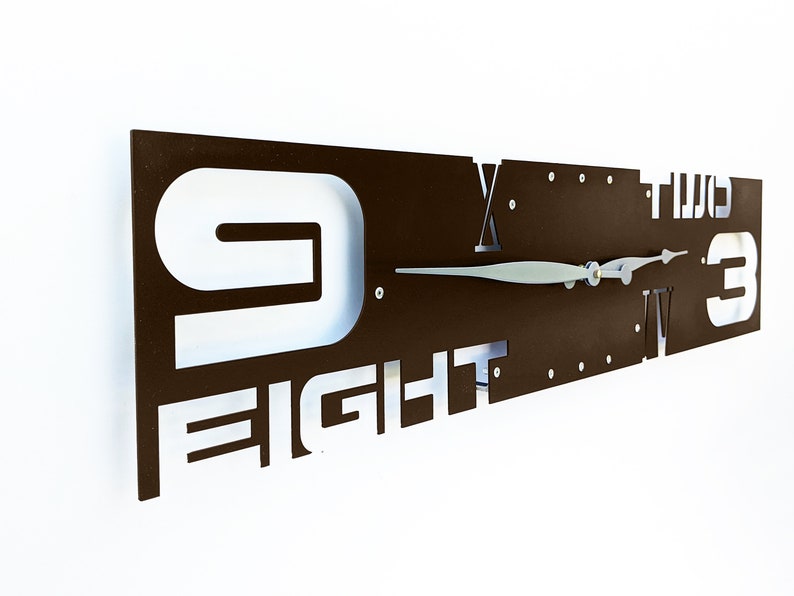 May include: A brown metal wall clock with white numbers and the word "FIGHT" in the design. The clock hands are silver.
