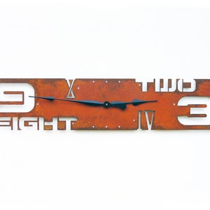 May include: A rusty metal clock with Roman numeral markings and white numbers cut out. The clock face is rectangular and the numbers "9 EIGHT TWO 3" are visible.