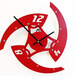 Peut inclure: Horloge rouge avec des aiguilles noires et des chiffres blancs sur un fond blanc. L'horloge est en métal et a un design unique.