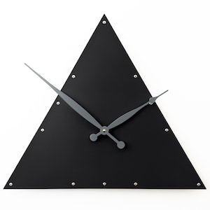 May include: A modern, minimalist wall clock with a black triangular face. The clock features gray hands and small silver studs around the perimeter. The design is simple and contemporary, suitable for various interior styles.