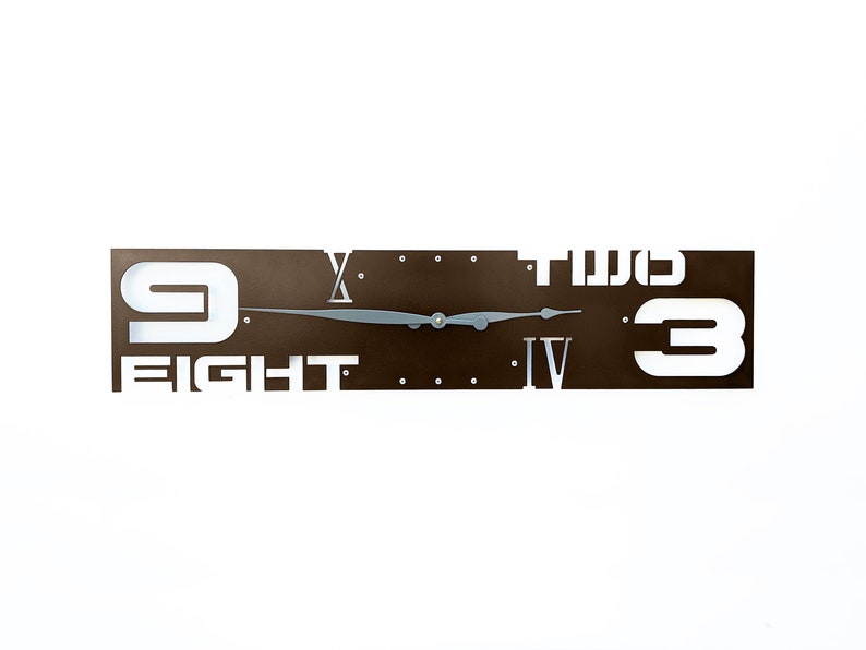 A dark brown rectangle shaped laser cut steel wall clock with gray hands.  It has the hours marked with metal rivets.  The clock and hands can be custom painted a variety of colors, chosen at checkout.  This clock has the numbers 4 and 10 as roman numerals, the numbers two and eight spelled out and the numbers 3 and 9 as numbers.  The rest of the numbers are left off.  This clock is available in 3 different sizes.  Handmade in Tucson, Arizona.