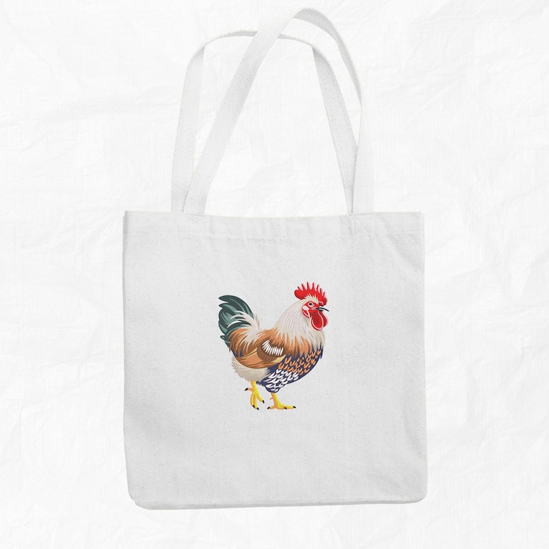 May include: A white tote bag with a colorful rooster illustration. The rooster is facing right and has a red comb and wattle.
