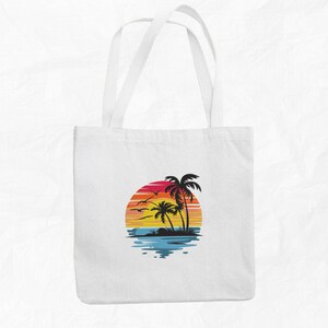 K&ouml;nnte beinhalten: Wei&szlig;e Einkaufstasche mit einem Grafikdruck von Sonnenuntergang und Palmen. Der Sonnenuntergang ist ein Farbverlauf von Orange, Rot und Gelb. Die Palmen sind schwarze Silhouetten.