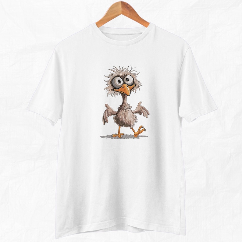 May include: White t-shirt with a cartoon illustration of a bird with large eyes and a funny expression.