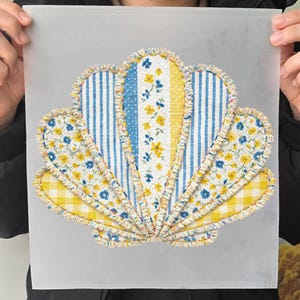 Może przedstawiać: Wzór muszli z tkaniny z różnymi wzorami. Projekt przedstawia niebiesko-białe paski, żółtą kratę i wzory kwiatowe. Krawędzie są postrzępione, a kolory obejmują żółty, niebieski i biały.