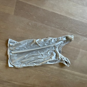 Könnte beinhalten: Ein weißes Satin-Tanktop mit Rundhalsausschnitt und dünnen Trägern.