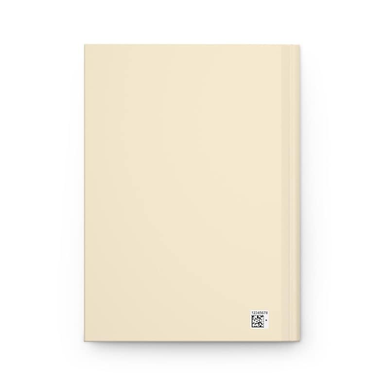 May include: A cream-colored journal with a smooth cover. The spine is visible on the right side. A small black and white barcode and a series of numbers are printed near the bottom right corner.