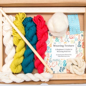May include: A weaving kit in a cardboard box, featuring a wooden frame, various colored yarns (white, yellow-green, teal, red), a wooden dowel, and a book titled "Weaving Texture". The book is a beginner's guide to weaving wall art.