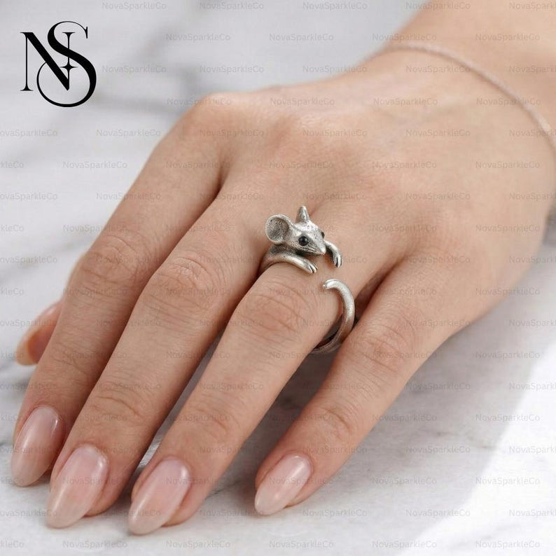 Op de afbeelding: Een set van drie keramische mokken met een gespikkelde, matte afwerking. De mokken zijn in cr&egrave;me, lichtgrijs en donkergrijs. Elke mok heeft een eenvoudig, minimalistisch ontwerp.