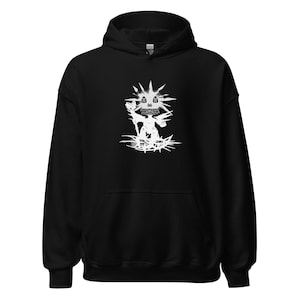 May include: A black hooded sweatshirt featuring a white graphic print on the chest. The design depicts a stylized creature with a spiky head, holding a staff, and standing on a circular base with radiating lines, all rendered in a distressed style.