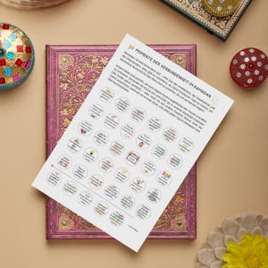 Könnte beinhalten: Ein bedrucktes Papier mit dem Text "30 MOMENTE DER VERBUNDENHEIT IM RAMADAN" und mehreren kleinen kreisförmigen Illustrationen. Das Papier liegt auf einem lila Notizbuch mit goldenen Akzenten, mit dekorativen Gegenständen drumherum.