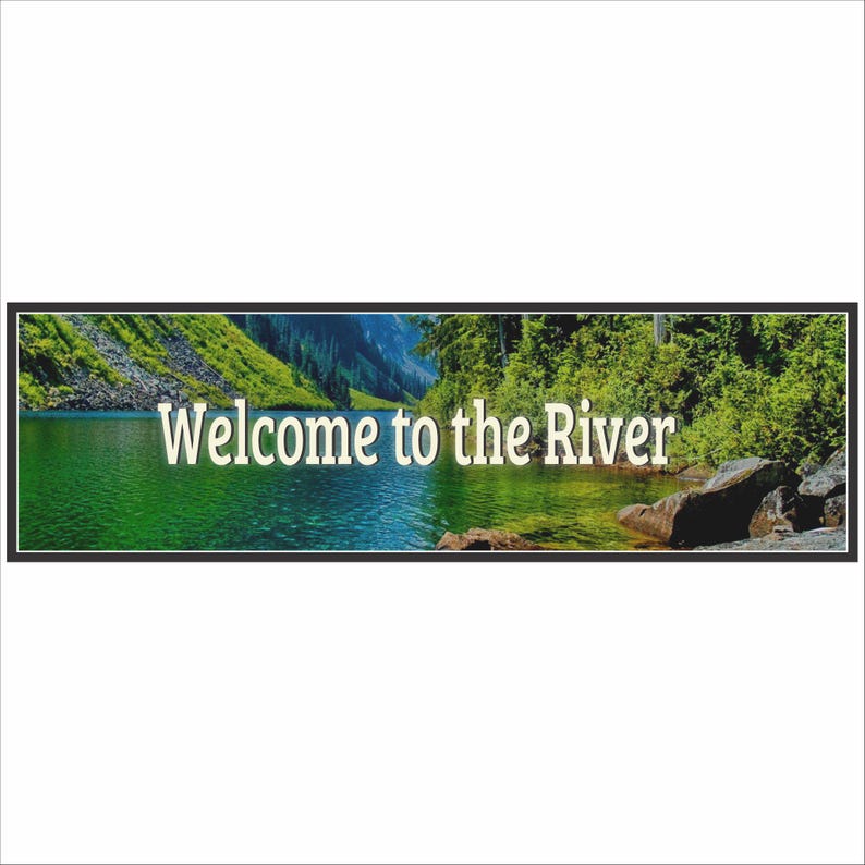 close up of welcome to the river sign with scenic water and forest background