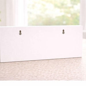wall sign showing keyhole mounting slots on rigid pvc backing